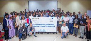 Man sieht eine große Gruppe von Menschen, die ein Banner in die Luft halten.